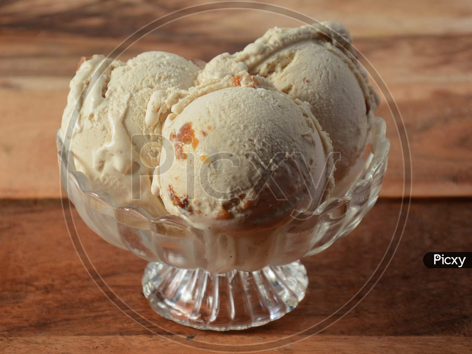 Honey Fig Ice Cream Scoops Served In A Glass Bowl Over A Rustic Wooden Table, Selective Focus