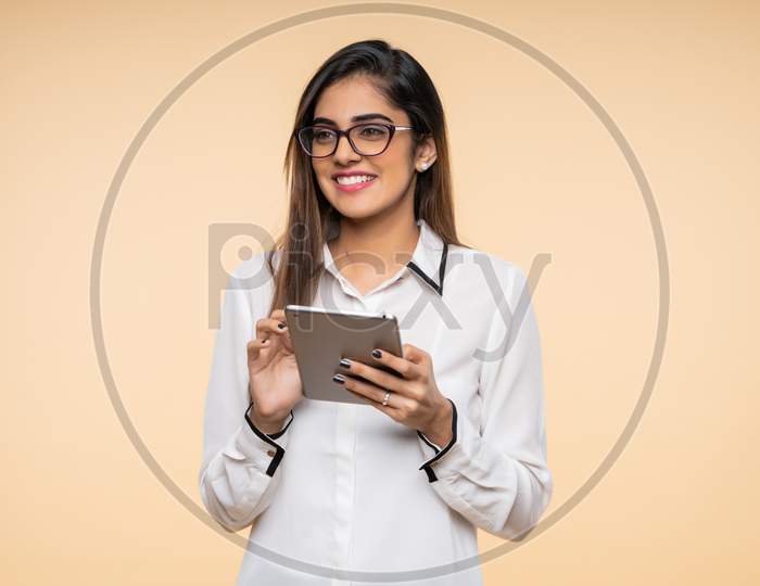 Indian smiling young woman using a Tab
