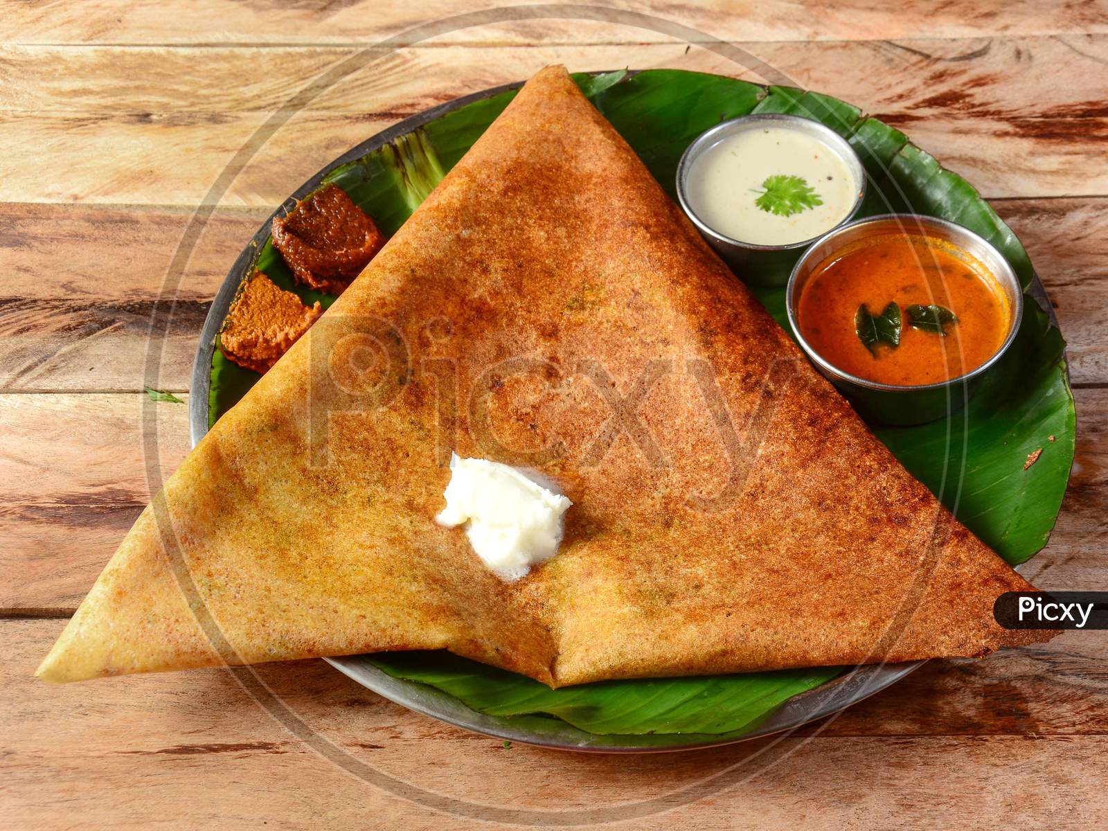 Mysore Masala Dosa, A Famous South Indian Traditional Breakfast With Filling Of A Mixture Of Mashed Potatoes Served With Different Chutney And Sambar Over A Rustic Wooden Background, Selective Focus