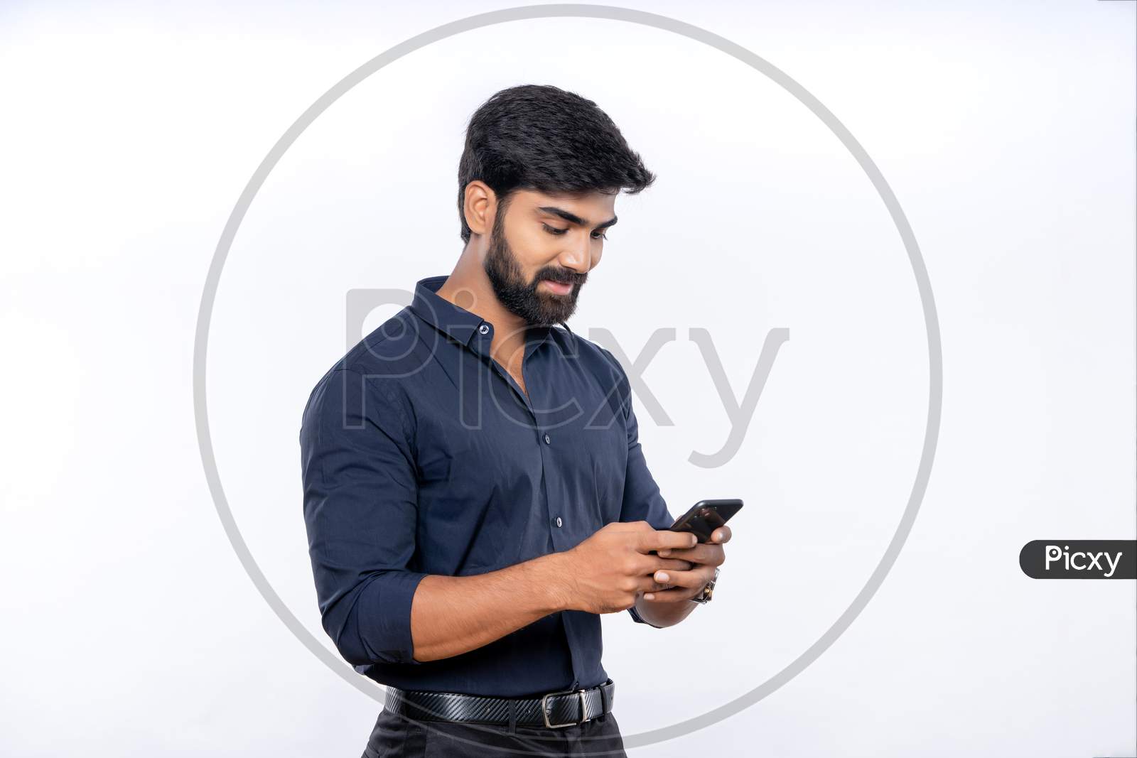 Indian smiling young man using mobile phone