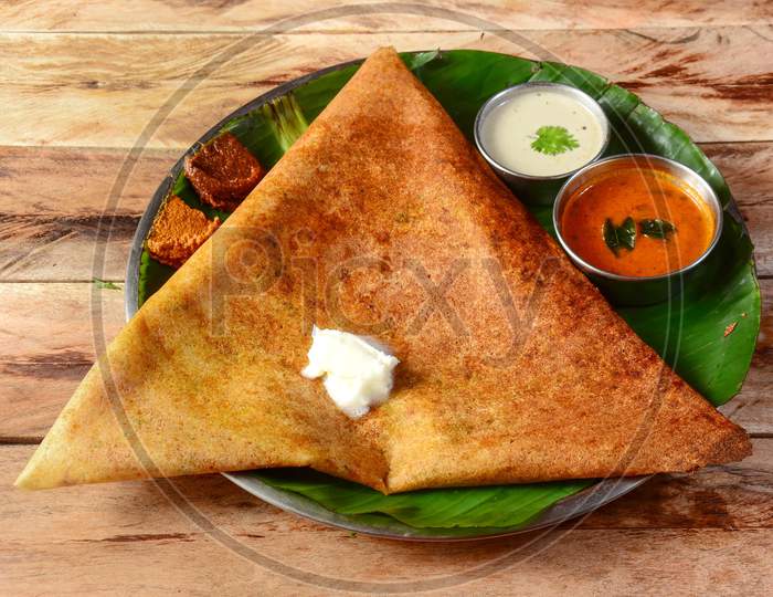 Mysore Masala Dosa, A Famous South Indian Traditional Breakfast With Filling Of A Mixture Of Mashed Potatoes Served With Different Chutney And Sambar Over A Rustic Wooden Background, Selective Focus
