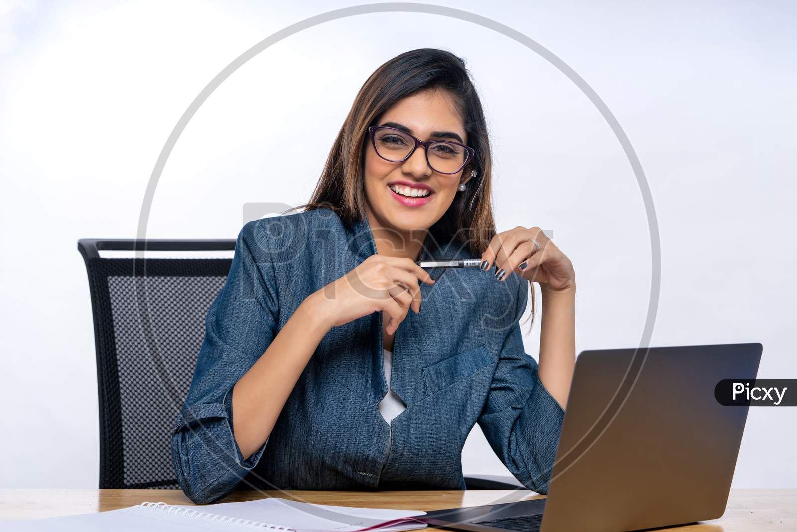Smiling Indian confident young woman working with a Laptop