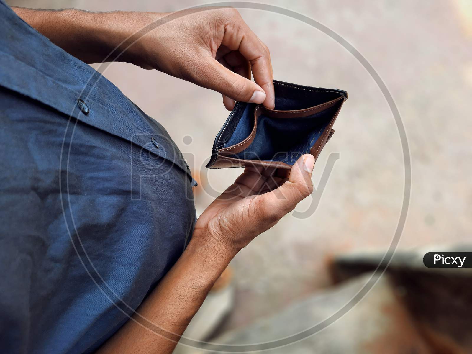Young Man Holding Empty Wallet In Hands Top View With Selective Focus