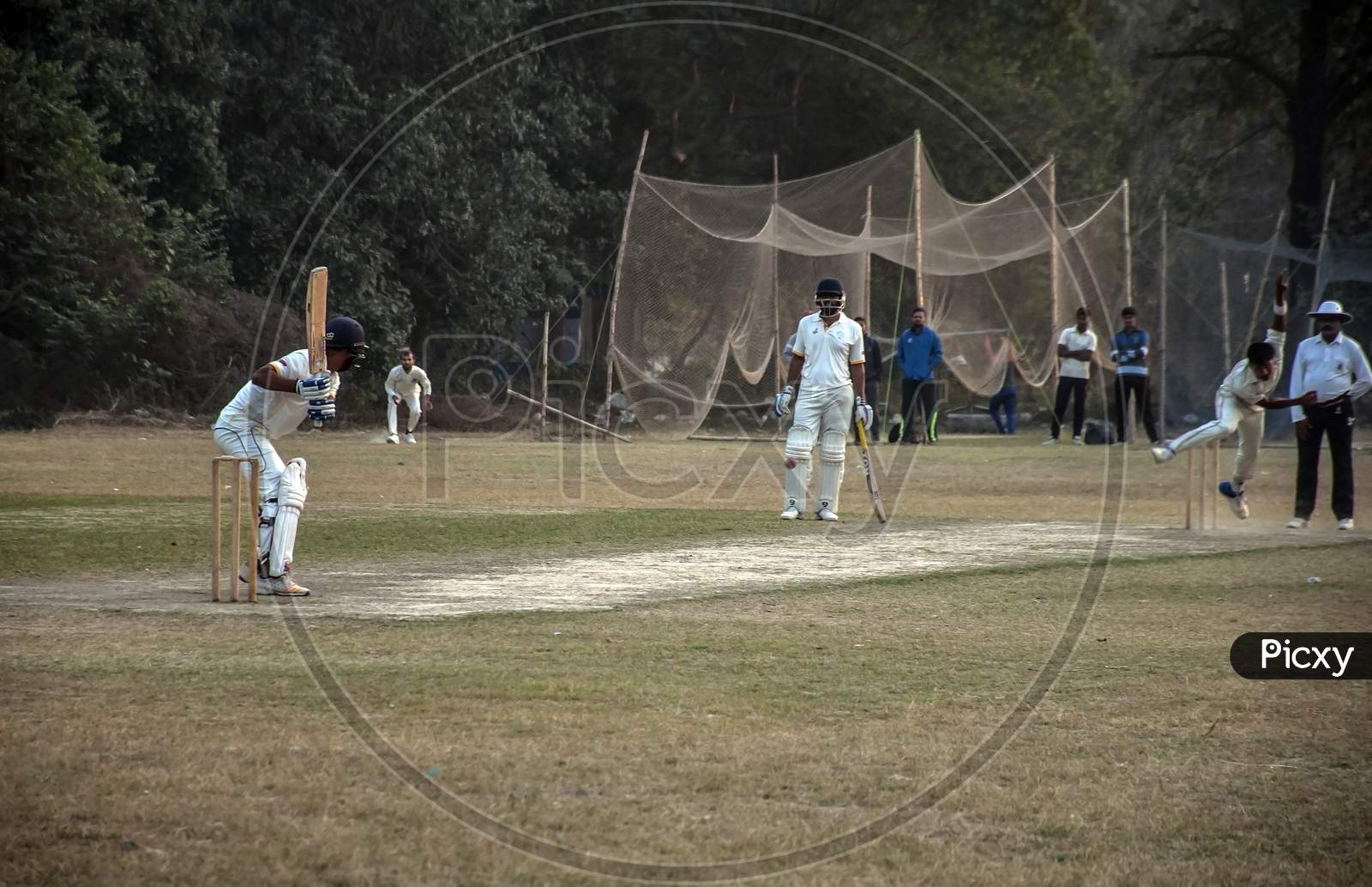 The bating and bowling action of a cricket ground.