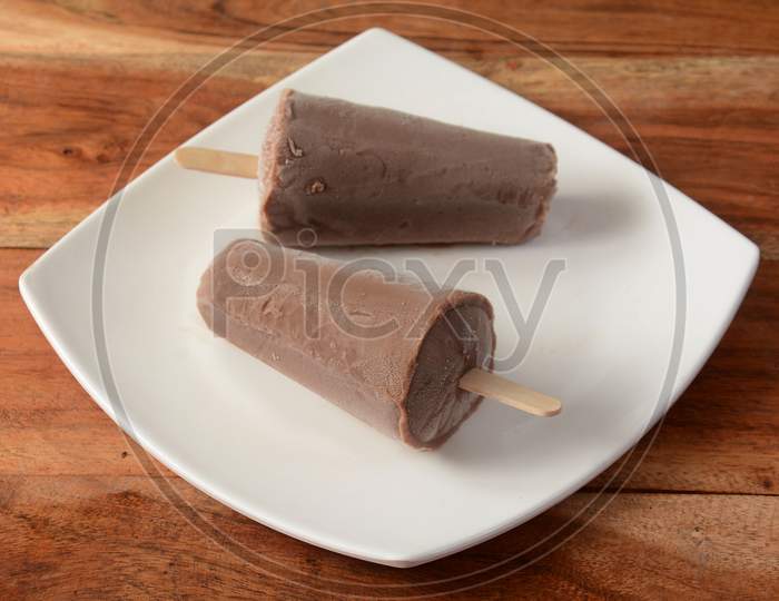 Chocolate Kulfi Served In White Plate Over A Rustic Wooden Background, Selective Focus