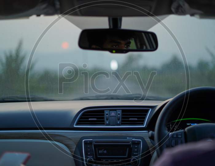 Car dashboard and sunset background