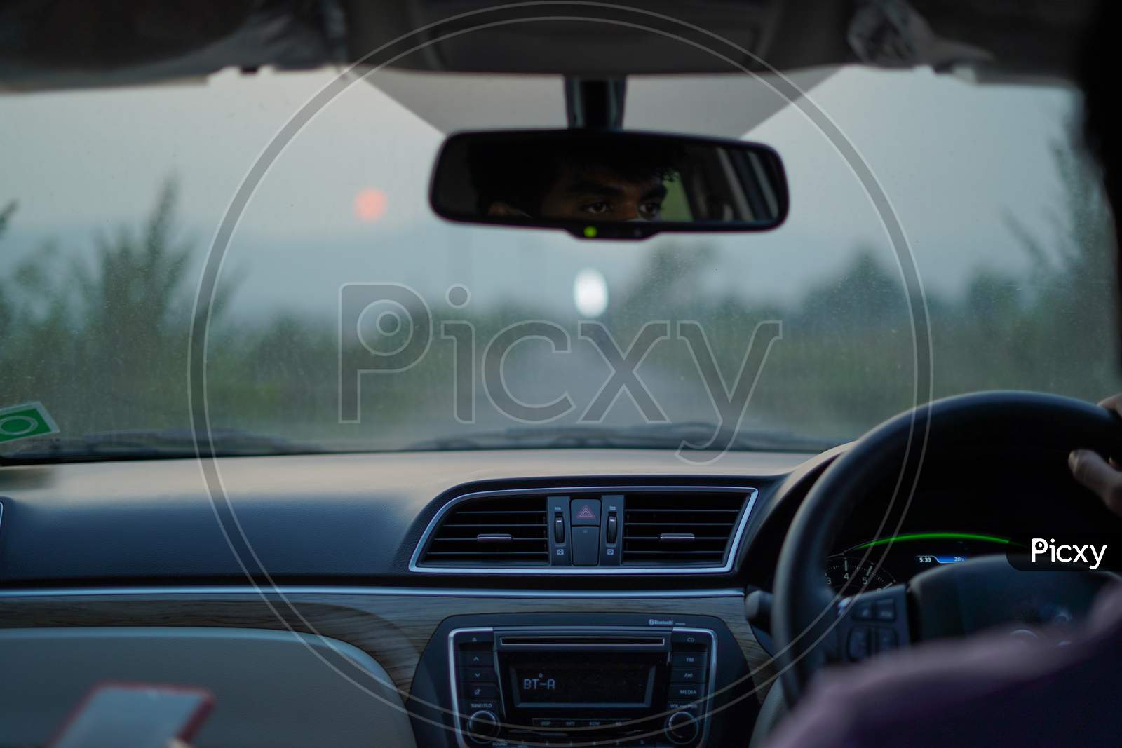 Car dashboard and sunset background