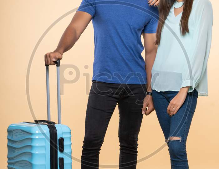 Indian young couple travelers with a trolley bag
