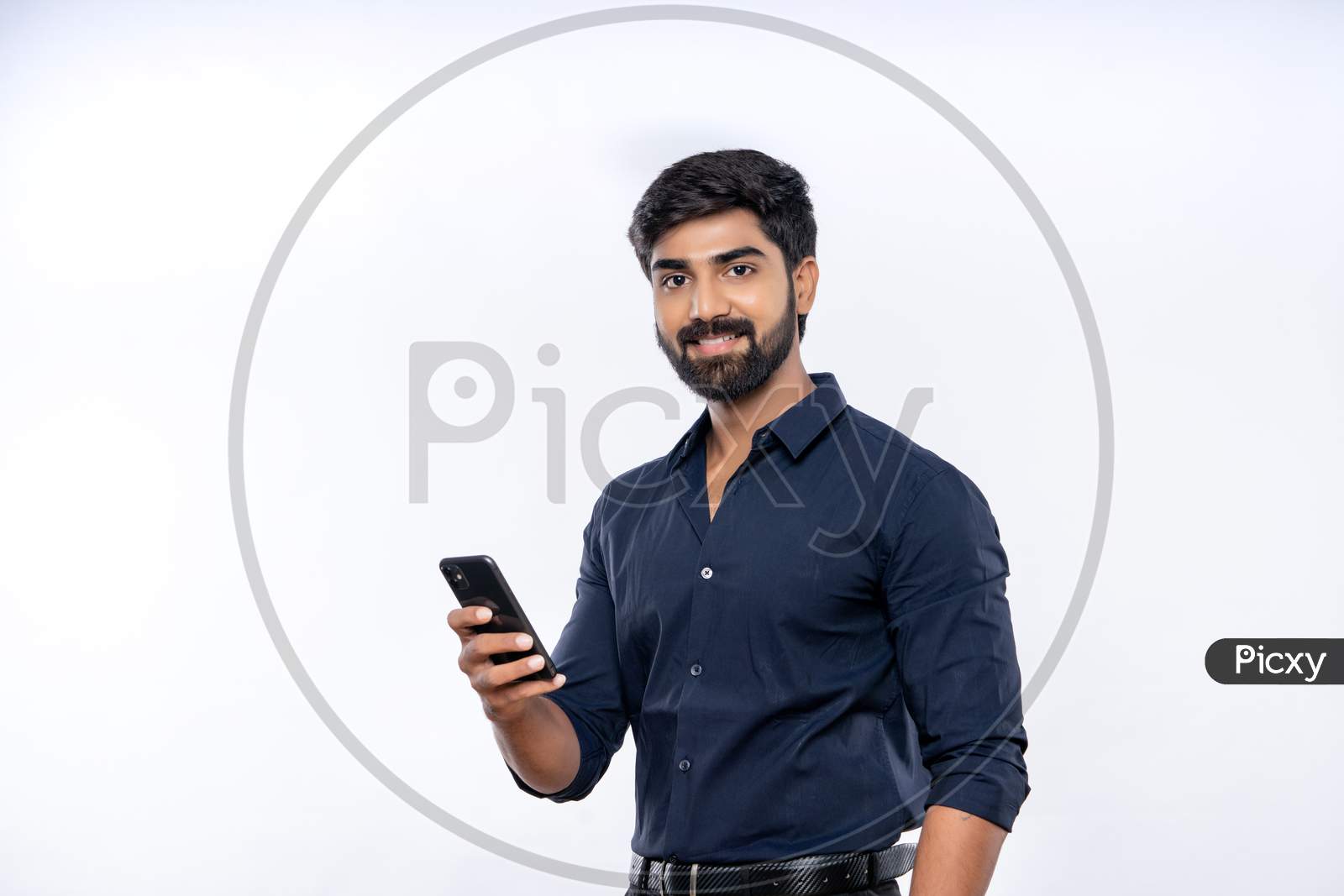Indian smiling young man using mobile phone