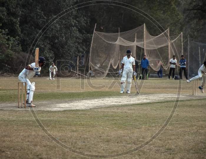 The bating and bowling action of a cricket ground.
