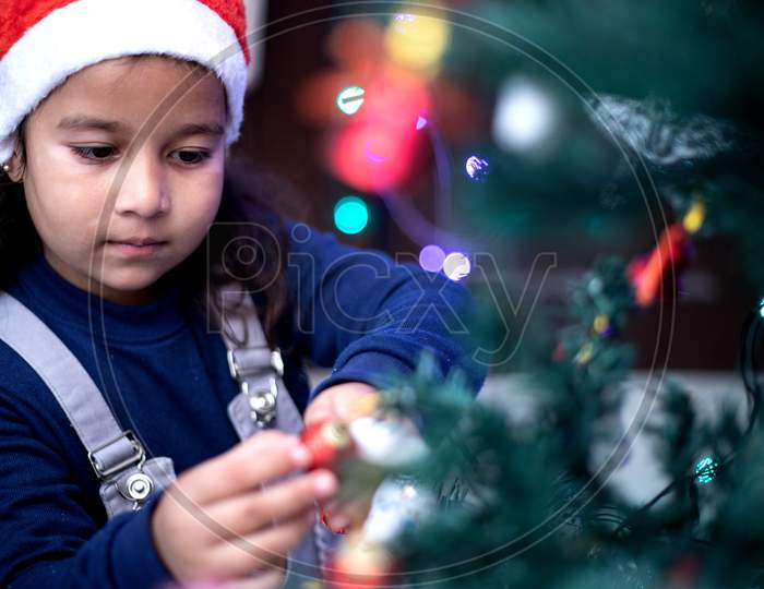 Child Decorating Christmas Tree At Home