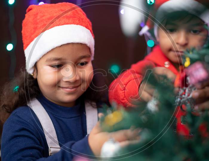 Happy Kids In Santa Cap Decorating Christmas Tree