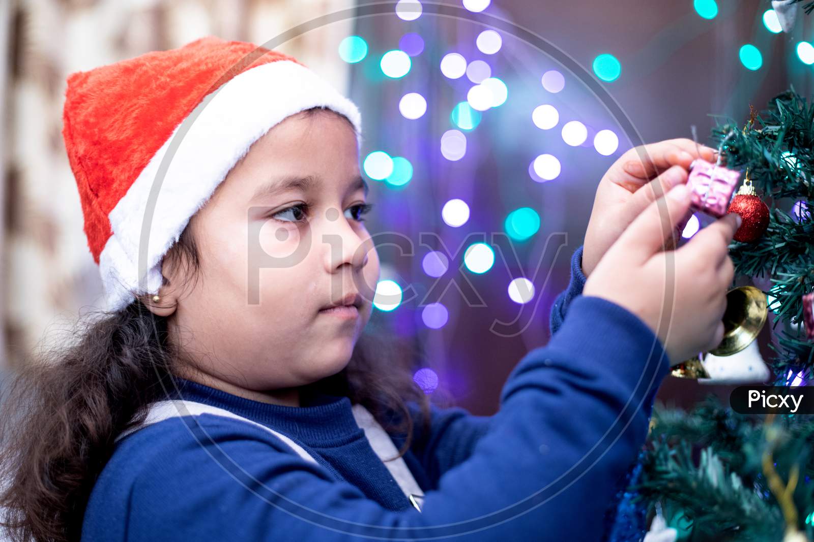 Girl Kid Checking Gift Hanging on  Christmas Tree