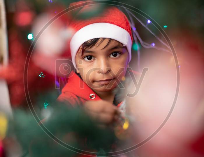 Child In Santa Cap Decorating Christmas Tree