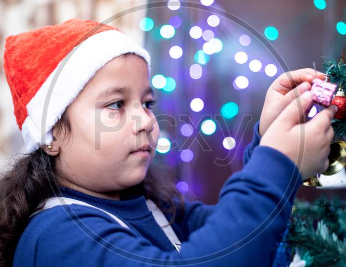Girl Kid Checking Gift Hanging on  Christmas Tree