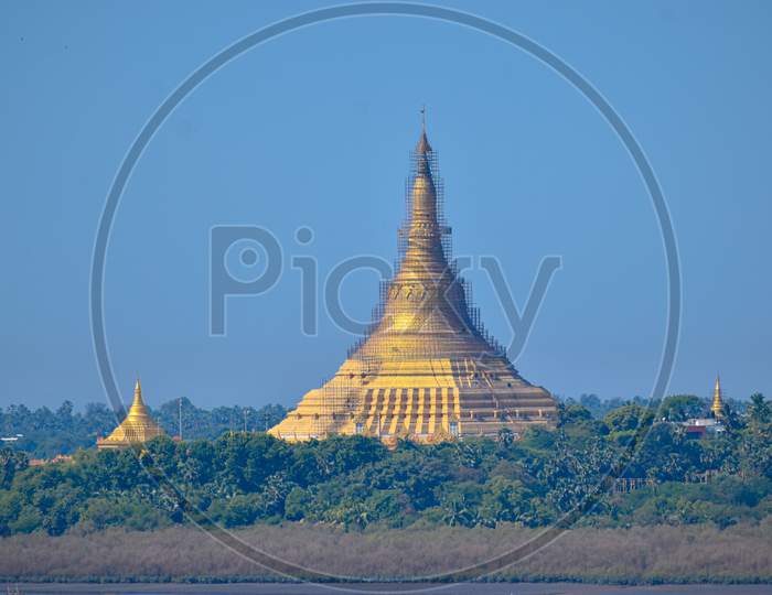 Golden Pagoda With Blue Skyline In Background And Greenery In Foreground In India, Gorai