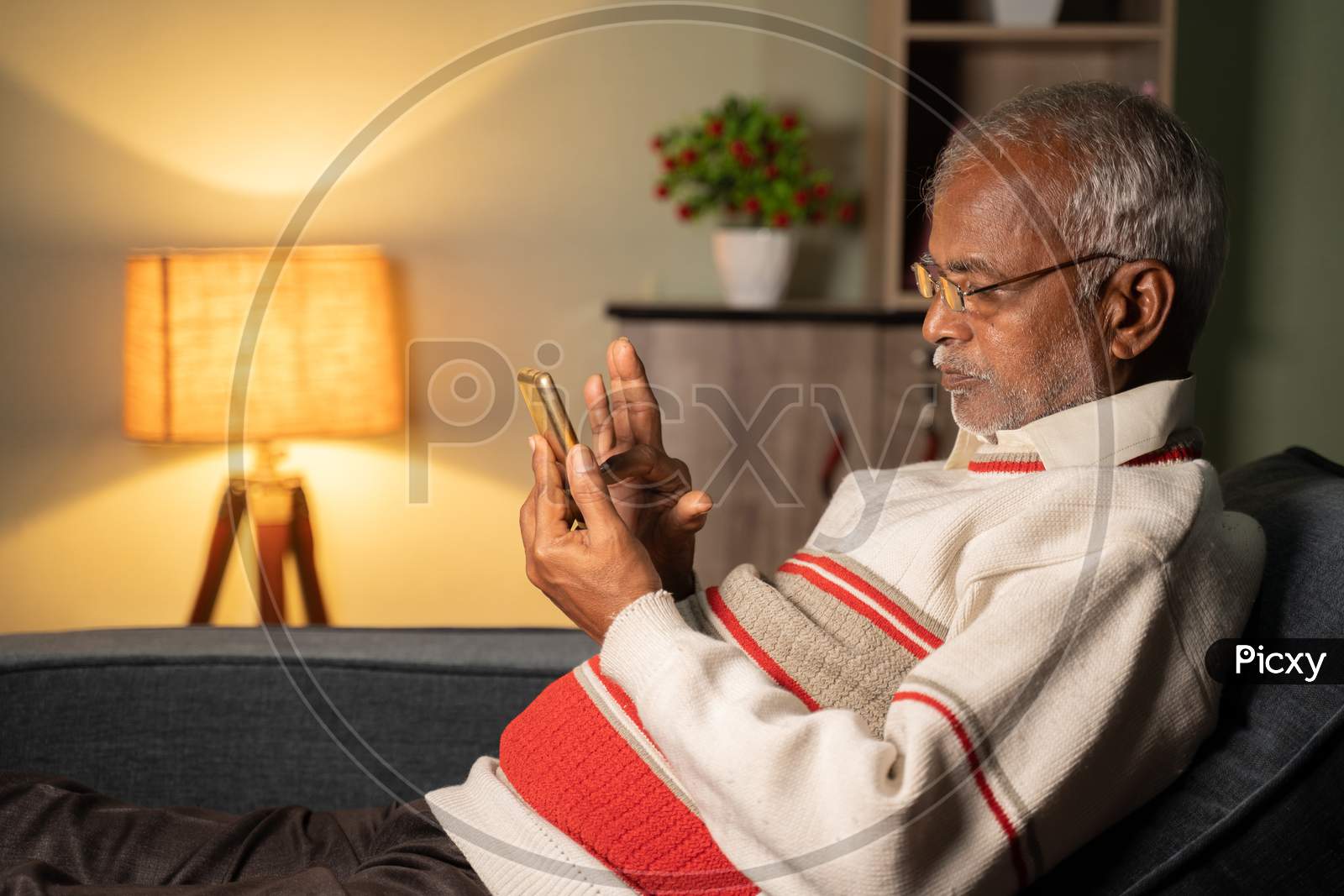 Old Man Busy Using Mobile Phone At Home While Sleeping On Sofa - Concept Of Senior People Using Technology, Internet And Social Media.