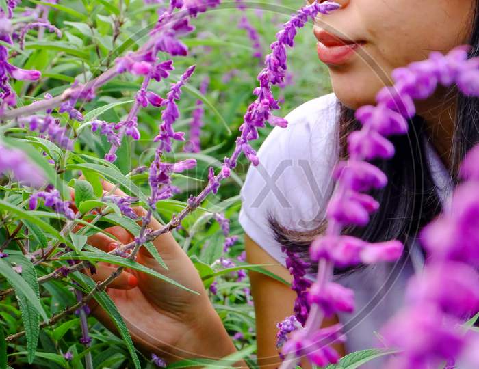 Cute Portrait Of Asian Woman With A Purple Lavender Flowers Background And Green Leaf
