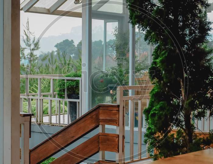 A View From The Balcony Of The Tropical House With Flowers And Glass Windows