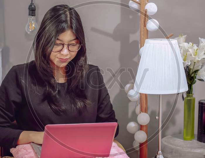 Woman work in front of the laptop sitting in the bedroom