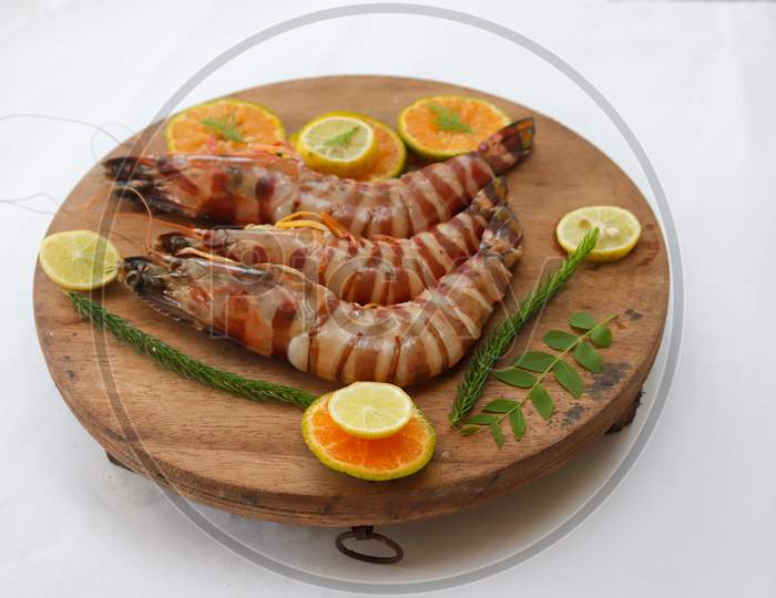 Fresh Giant Tiger Shrimp Decorated With Spices And Herbs On A Wooden Pad.Isolated On White Background.