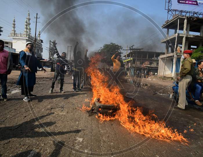 Asom Sankhyalaghu Sangram Parishad activists burn a tyre as they block a road, in support of the nationwide strike called by agitating farmers against Centre's farm reform laws, in Nagaon District of Assam on Dec 8,2020.
