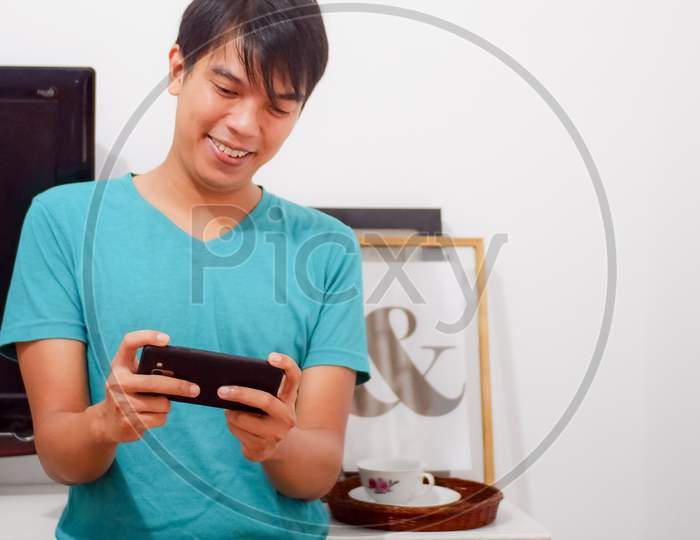 A Boy Having Fun Playing Games On Smartphone