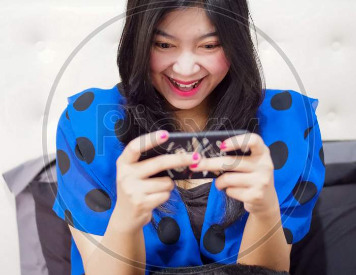 A Girl Watching Mobile Phone Very Excited Playing Online Games