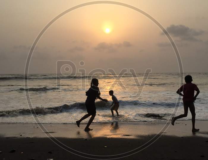 Sunset on beach with children playing
