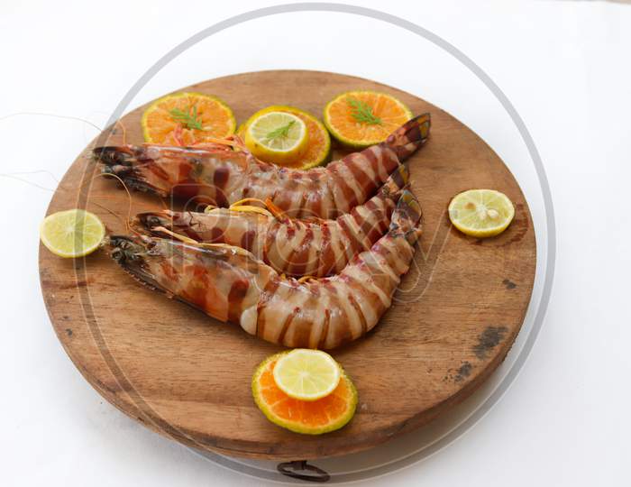 Fresh Giant Tiger Shrimp Decorated With Spices And Herbs On A Wooden Pad.Isolated On White Background.