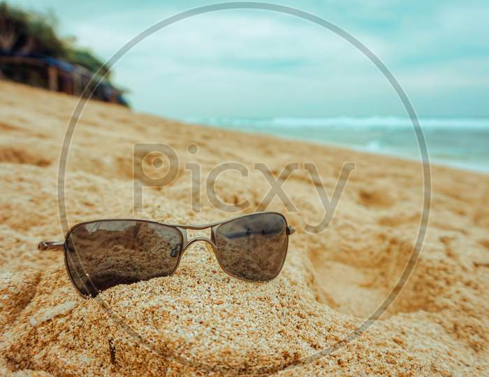 Cool Sunglasses On The Sand With A Beautiful Views At Indrayanti Beach In Gunung Kidul, Yogyakarta - Indonesia
