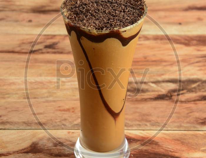 Chocolate Cold Coffee Served In A Glass Over A Rustic Wooden Background,A Refreshing Drink For Summer Days, Selective Focus On Top