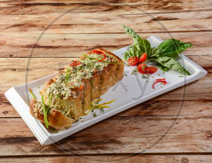 Three Cheese Garlic Bread Or Baguette, Consists Of Bread Topped With Cheese, Garlic, Olive Oil And Herbs, Served Over A Rustic Wooden Background, Selective Focus
