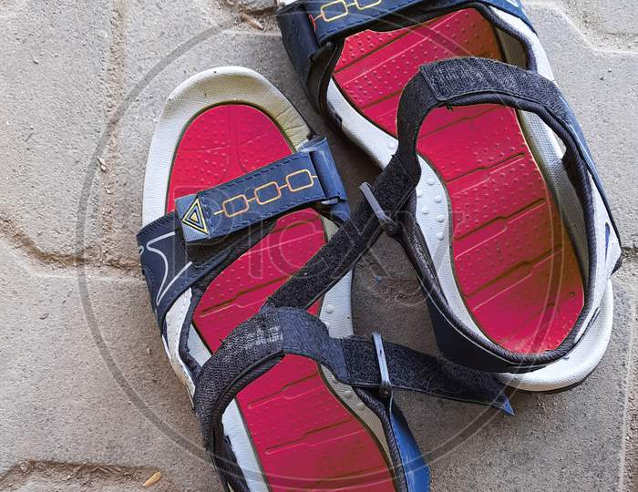 Closeup Of Pair Red Or Pink And Blue Color New Sandals In A Empty Road