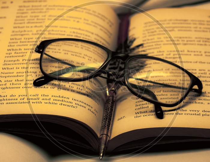 glasses on a book along with a pen
