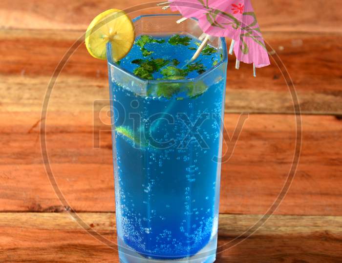 Blue Lagoon Cocktail Decorated With Lemon Slice And Mint Leaves. Selective Focus On Top