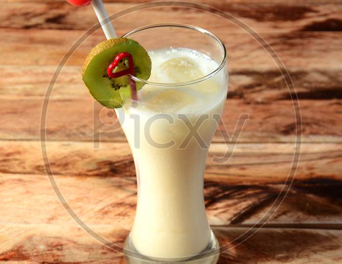 Fig Milkshake, Blended With Fig Fruit And Icecream, Served In A Glass Over A Rustic Wooden Background, Selective Focus On Top