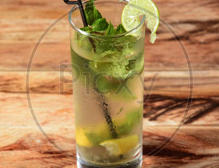 Lemon Mojito Served In A Glass Over A Rustic Wooden Background,A Refreshing Drink For Summer Days, Selective Focus On Top