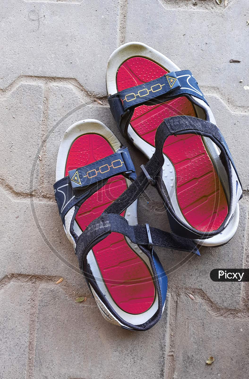 Closeup Of Pair Red Or Pink And Blue Color New Sandals In A Empty Road