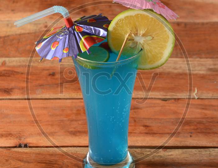 Blue Lagoon Cocktail Decorated With Lemon Slice And Mint Leaves. Selective Focus On Top