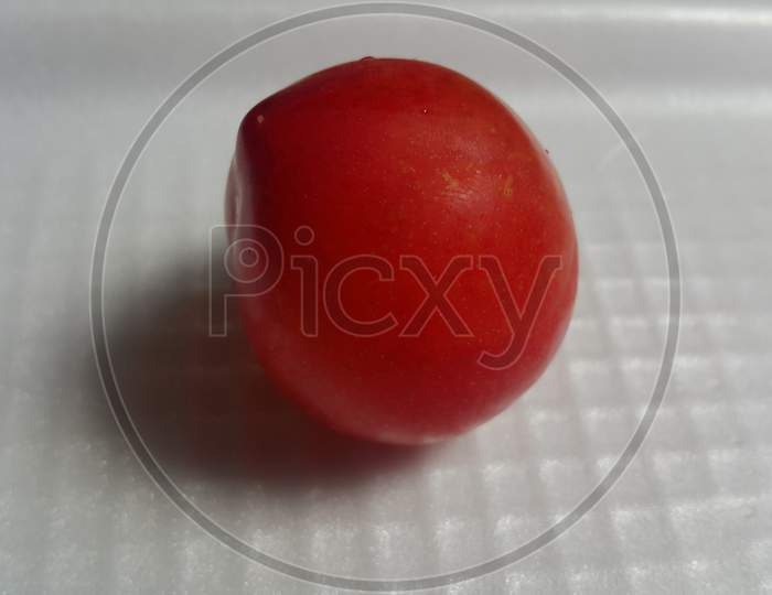 Closeup View Of Red Plum On A White Grey Background
