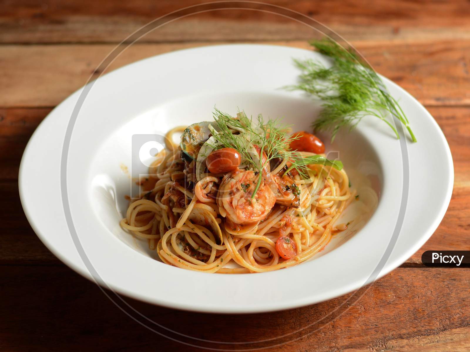 Italian Seafood Pasta Pescatore Served In A White Plate On A Rustic Wooden Table, Selective Focus
