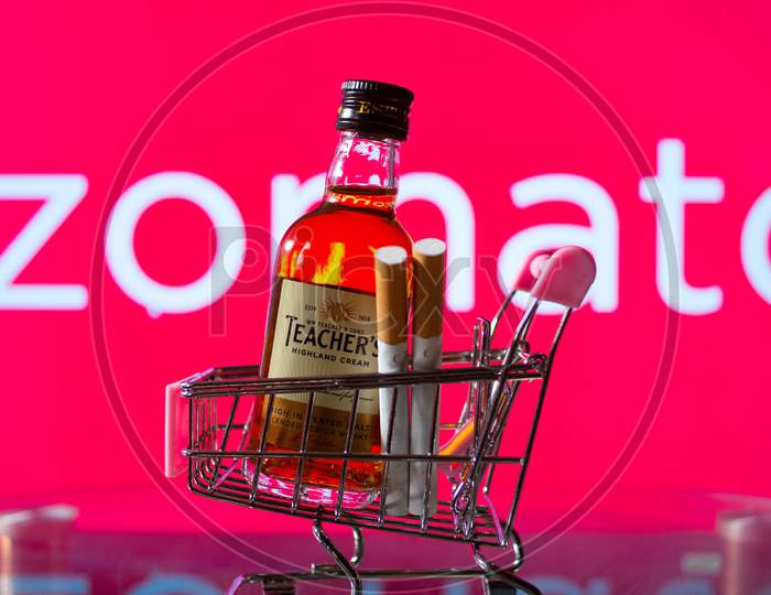 A Bottle Of Whiskey In A Trolley In Front Of A Zomato Board