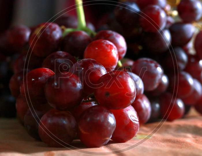 Healthy fruits Red wine grapes background/ dark grapes/ blue grapes/wine grapes,Red wine grapes background/dark grapes,blue grapes,Red Grape in a supermarket local market bunch of grapes ready to eat