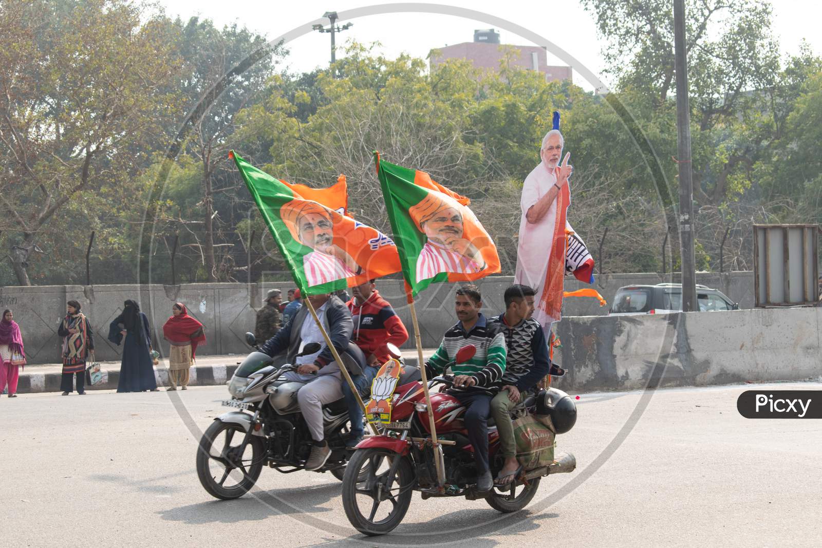 Men riding bike with BJP Flags during Bharatiya Janata Party campaign for Delhi Assembly Election 2020
