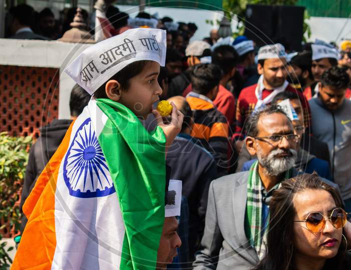 A child having sweets during celebration of Aam Aadmi Party AAP victory in Delhi Assembly Election 2020