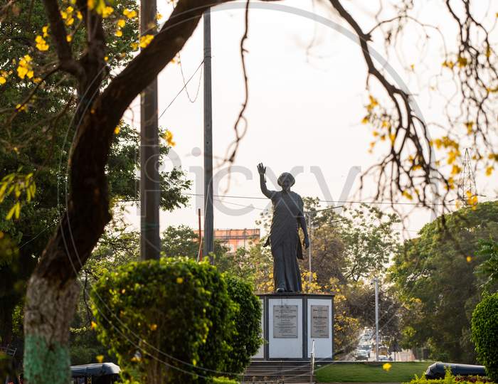 View of Indira Gandhi Statue against yellow flowers