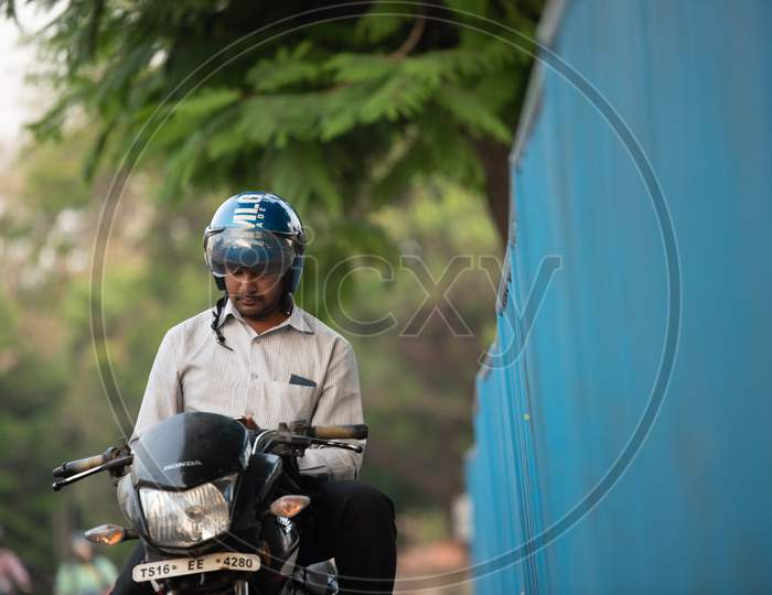 Indian man waiting wearing a helmet on the bike