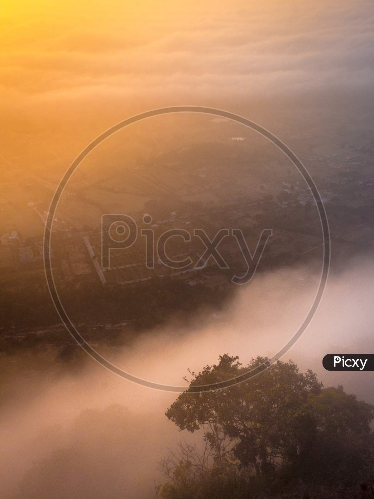 Fog rushing hilltop during the sunrise at Nandi Hills, Bengaluru