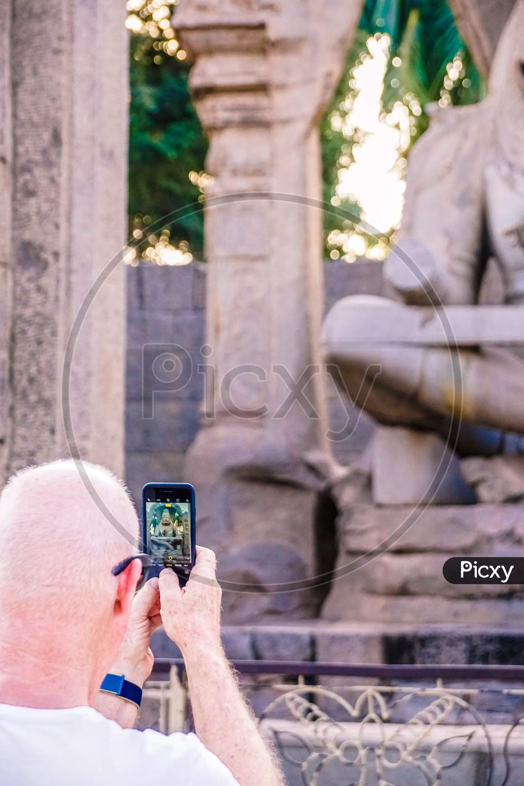 A Foreigner taking a picture of statue with his phone